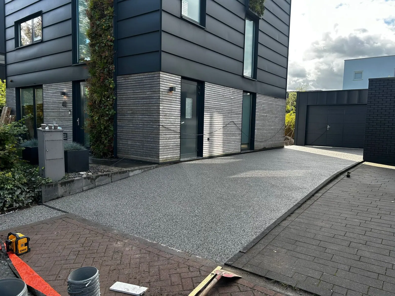 Grindpad langs een moderne woning, aansluitend op de klinkers van de straat.
