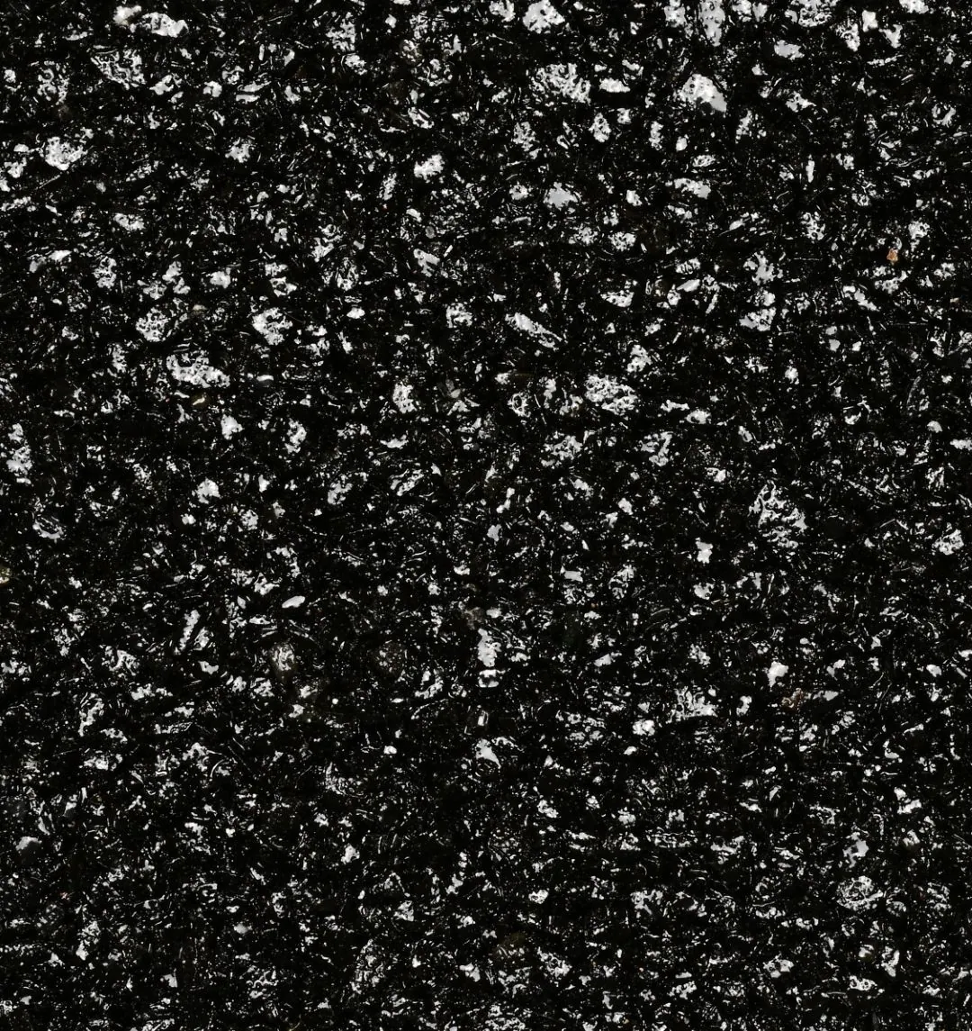Kleurstaal harsgebonden grind Deep Black: Diepzwarte, licht glanzende korrels. Strak en uitgesproken, met veel contrast tegen lichte gevels en groen